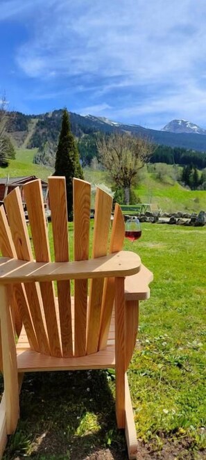 A wooden Adirondack chair outdoors with a mountainous landscape in the background. - Hôtel les Playes (Villard-de-Lans)