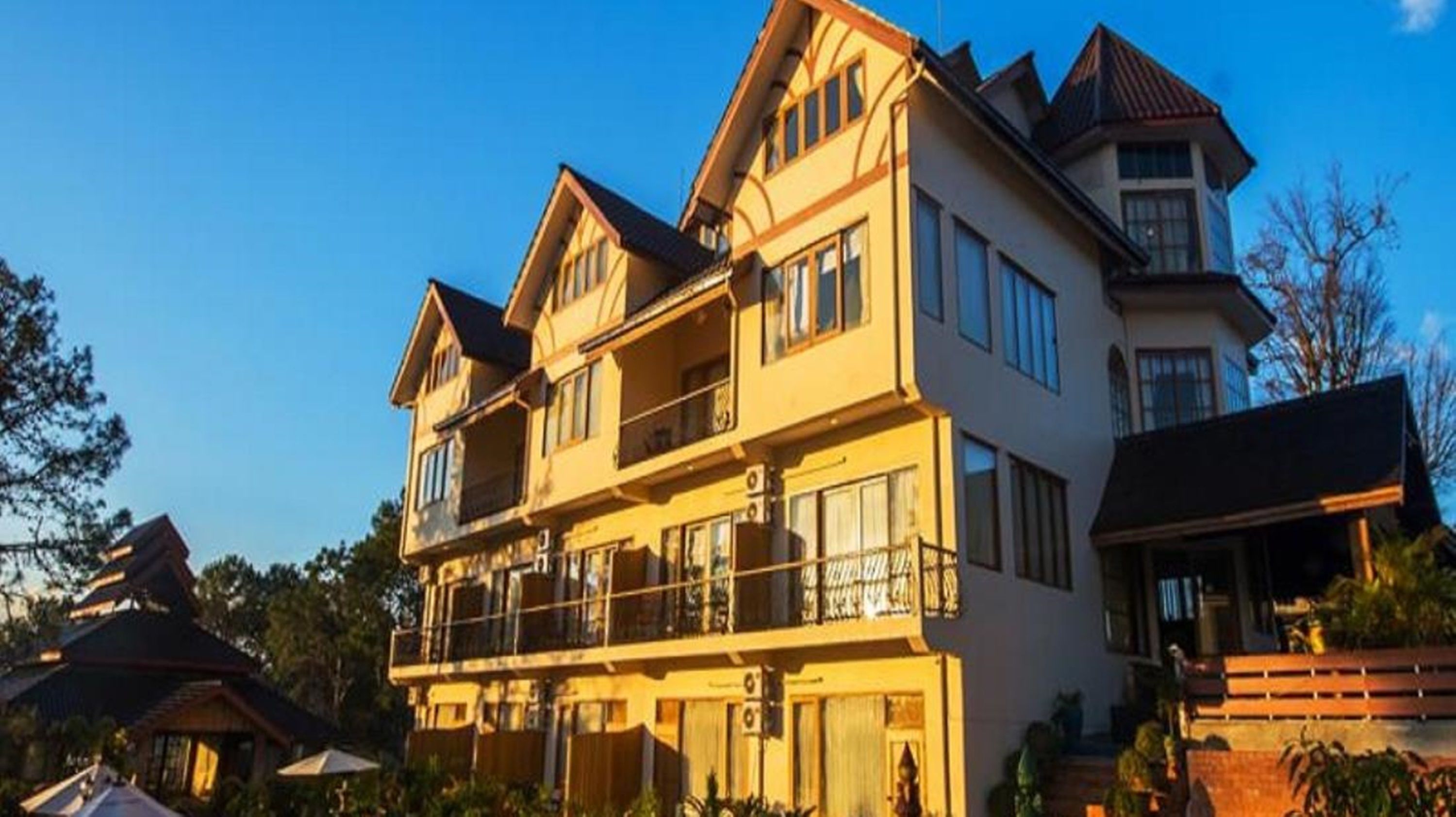 A multi-story hotel with a traditional architectural style, featuring balconies and large windows.
