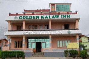 A hotel named Golden Kalaw Inn with a prominent sign, a two-story structure, and a welcoming entrance.