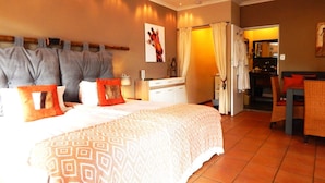 A hotel room with a bed, a desk, and a bathroom visible through an open door. - Khashamongo B&B (Cape Town)