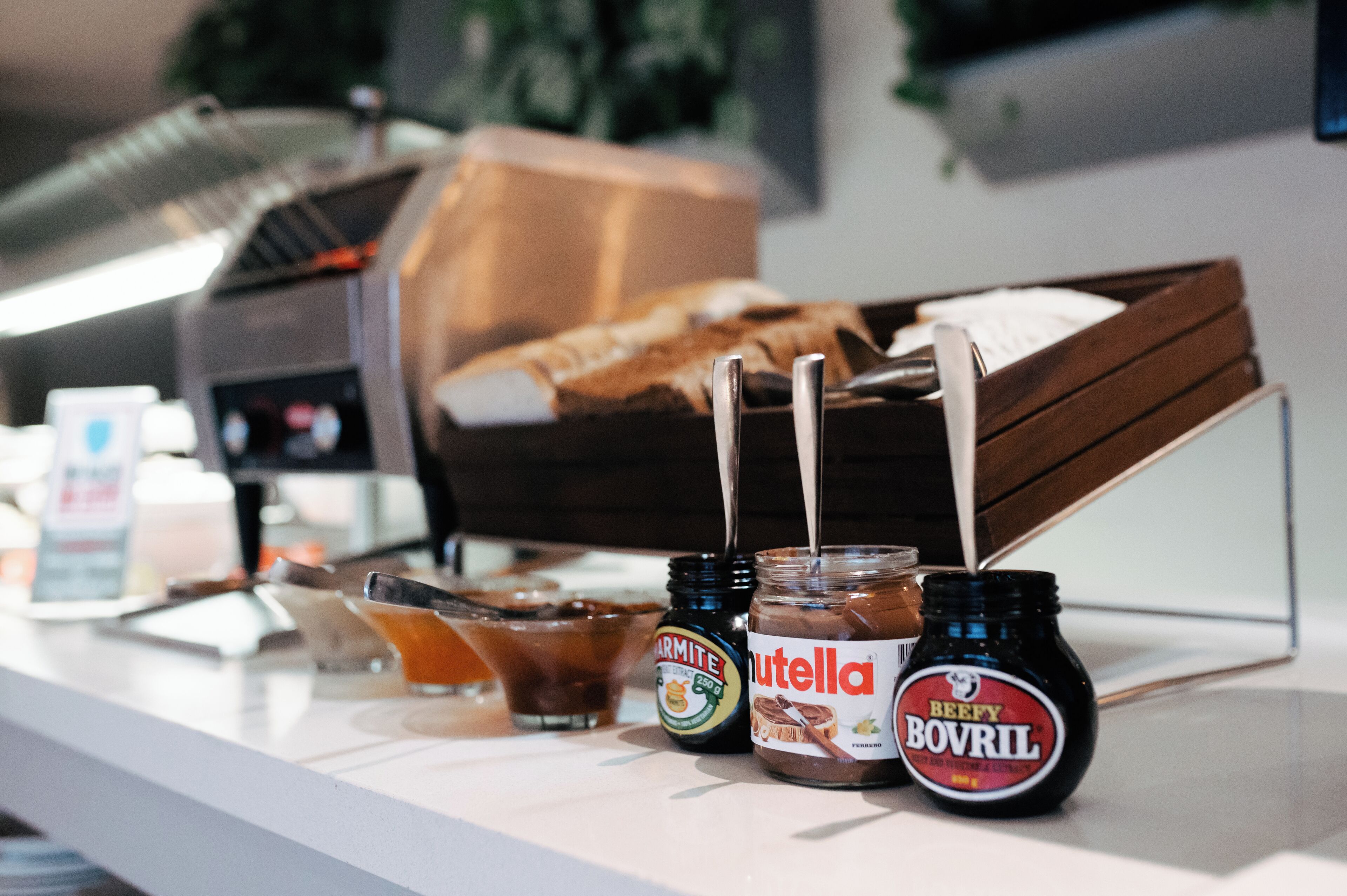 A breakfast buffet with various spreads, including Nutella and Bovril, and a selection of drinks.