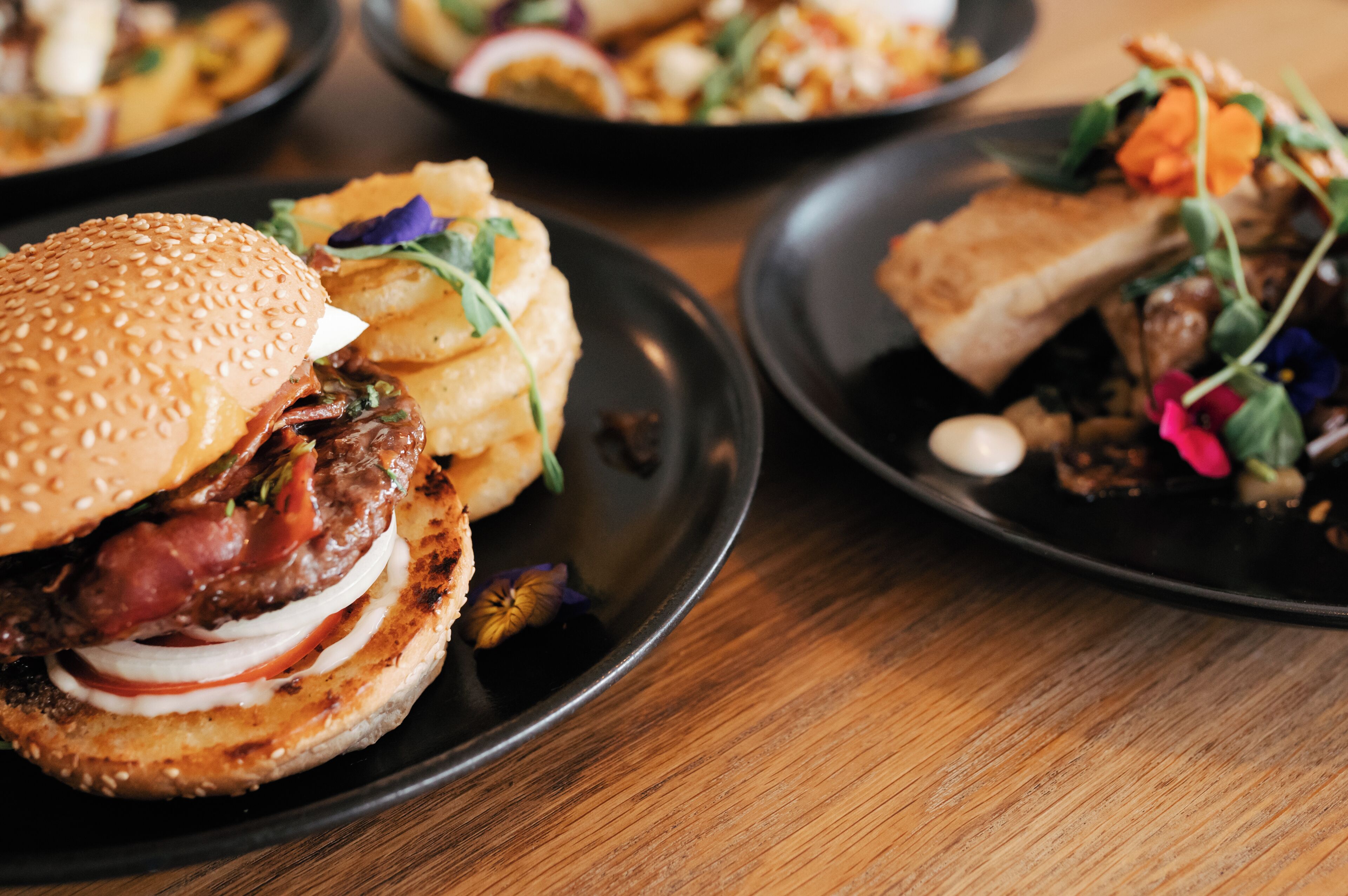 A dining table with plates of food, including a burger and a salad.