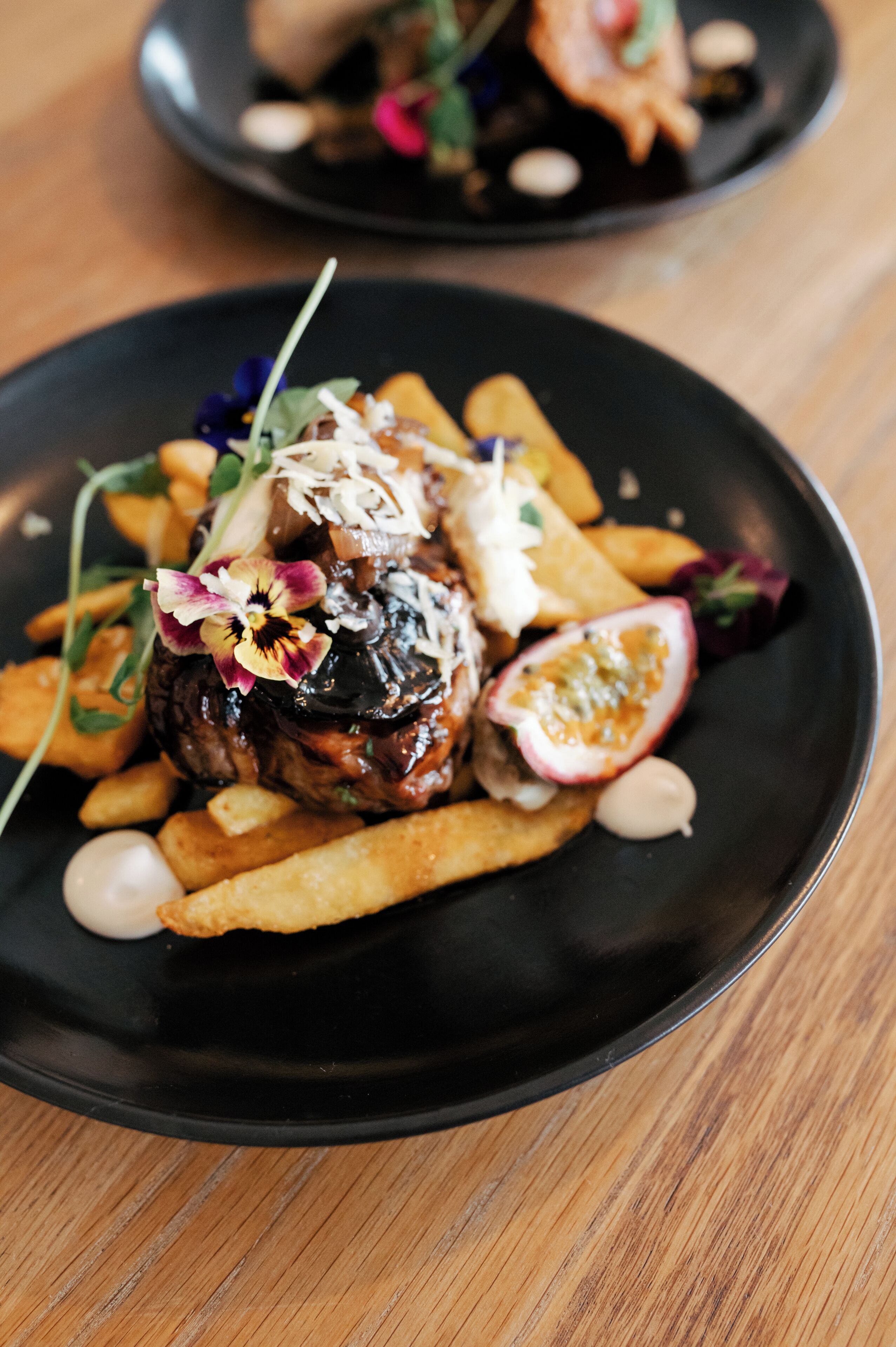 Une assiette contenant un steak, des frites et une portion de fruits.