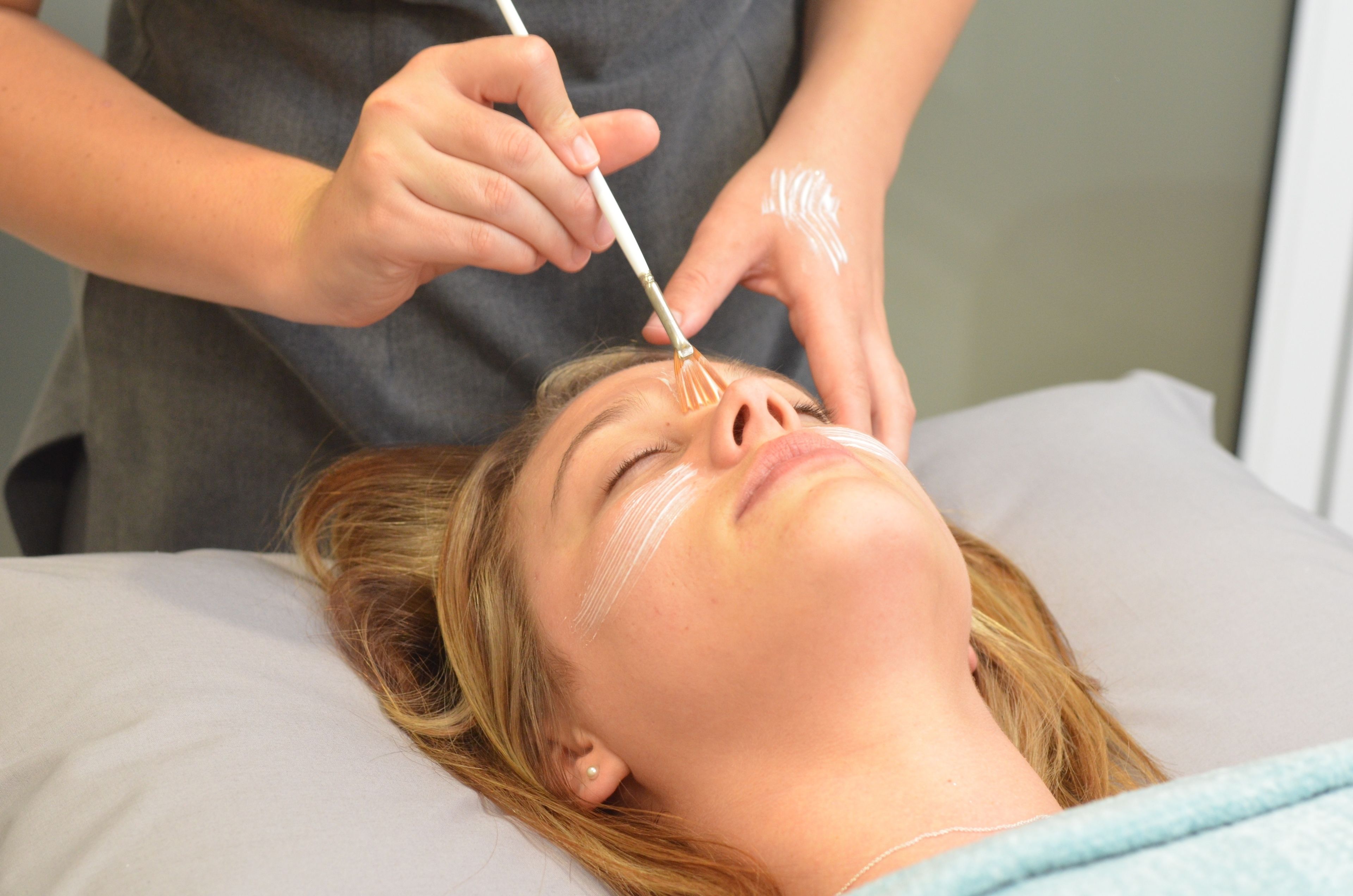 A person lying on a bed receiving a treatment.