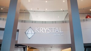 A shopping mall interior with a prominent sign for 'KRYSTAL BEACH'. - Krystal Beach Hotel (Cape Town)