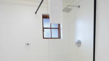 A bathroom with a white sink, toilet, and shower.