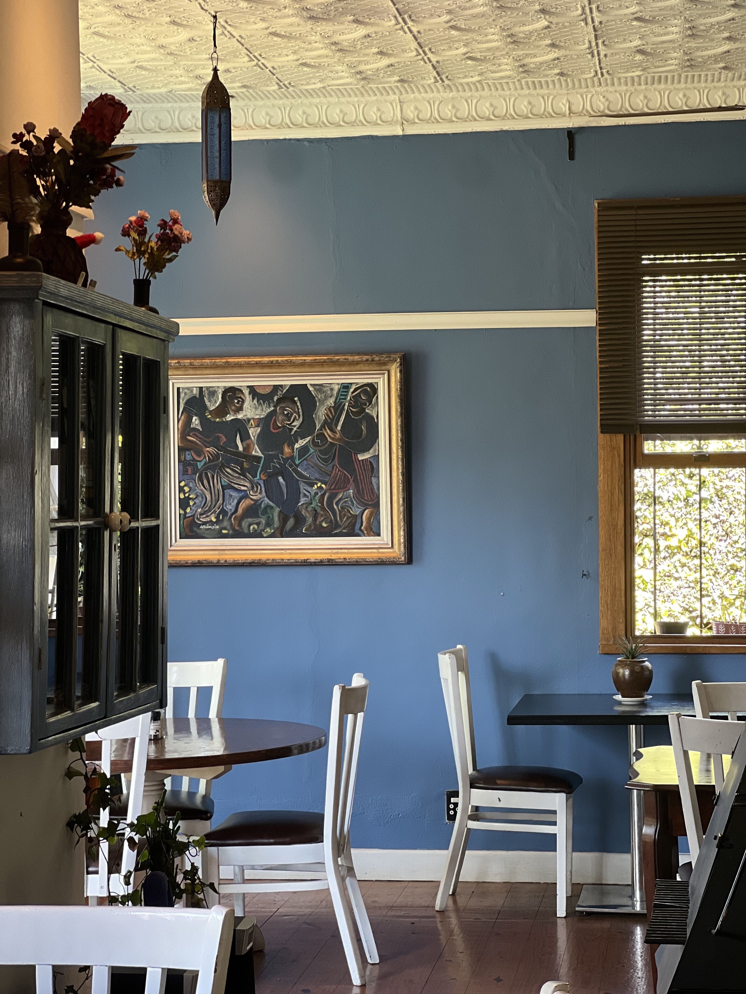 Un coin repas comprenant une table, des chaises, un buffet et un tableau accroché au mur.