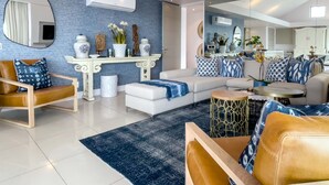 A modern living room with a sofa, armchairs, a coffee table, and decorative items. - Le Paradis Penthouse Apartment (Hermanus)