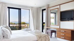 Une chambre d’hôtel avec un grand lit, un bureau avec un téléphone, une télévision et une vue sur l’extérieur.