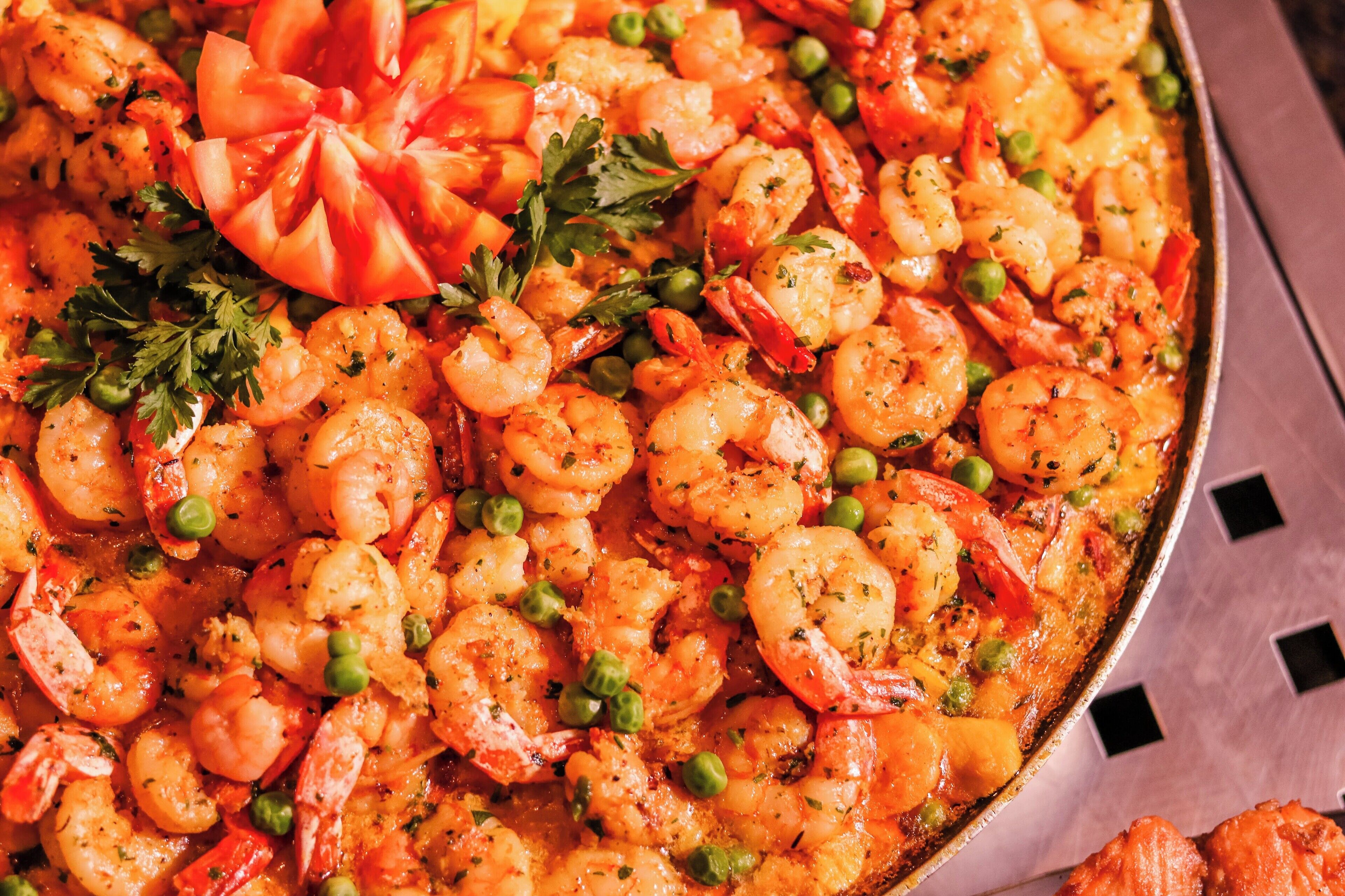 Primer pla d'un plat de marisc amb gambes, rovides i tomàquets.