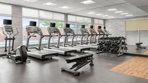 A gym with treadmills, elliptical machines, and a bench press. - Fairfield Inn & Suites by Marriott Alexandria (Alexandria)