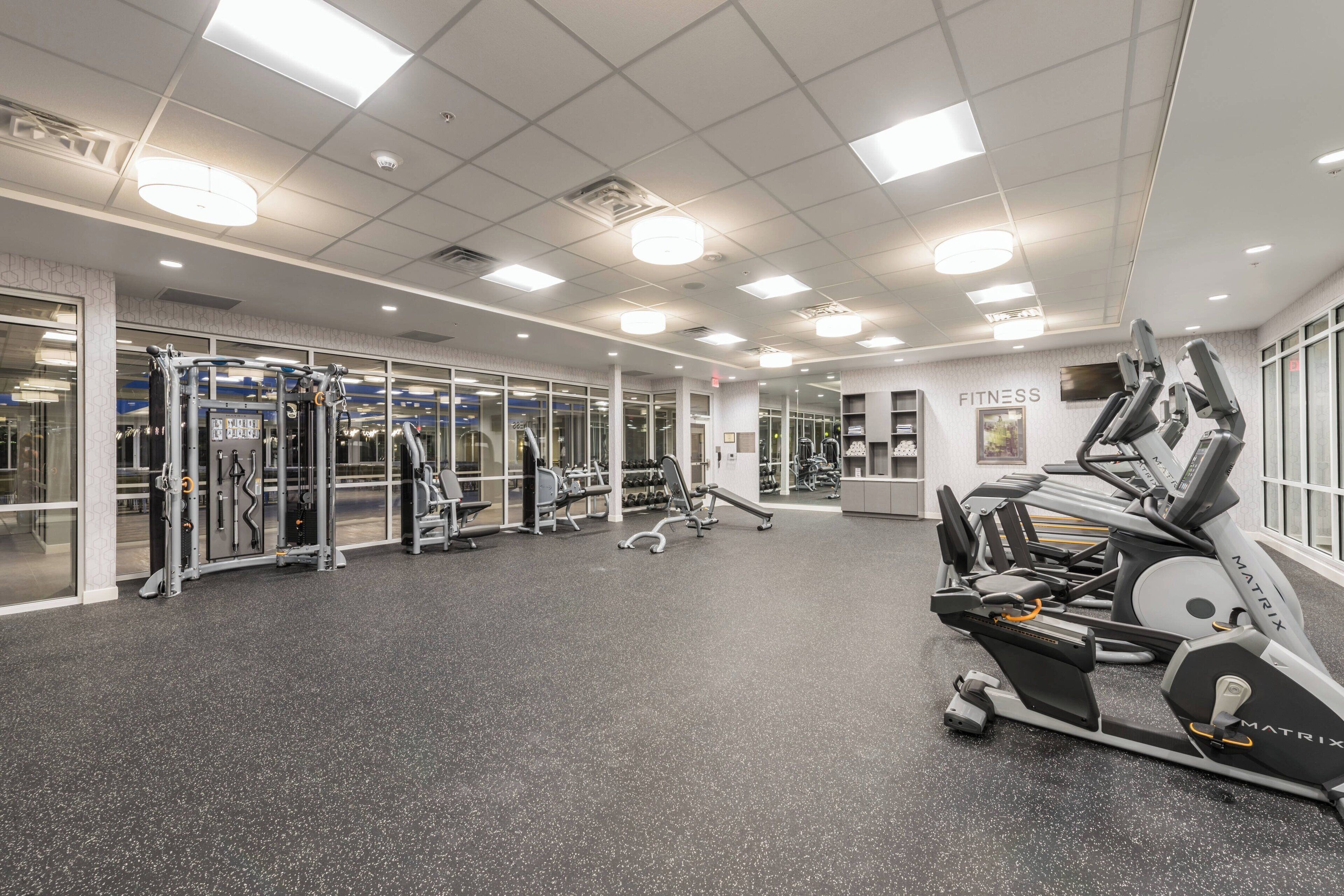 A gym with treadmills, weight machines, and mirrors.