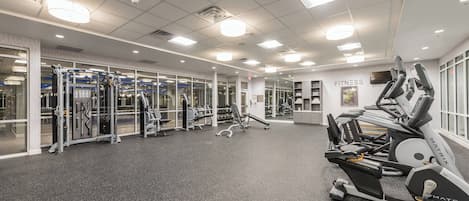 A gym with treadmills, weight machines, and mirrors.