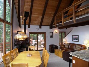 Ein großzügiger Wohnbereich mit Esstisch aus Holz, Stühlen, einer Couch und einer Küchenzeile.
