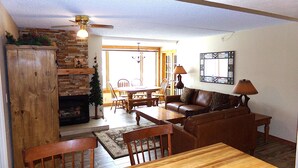 A living room with a fireplace, a dining area, and a sofa. - Summit House 2 bed 2 bath B (Copper Mountain)