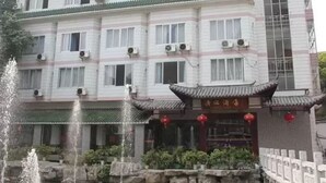 A multi-story building with traditional architectural elements, including a tiled roof and a courtyard with a fountain. - Li River (Guilin)