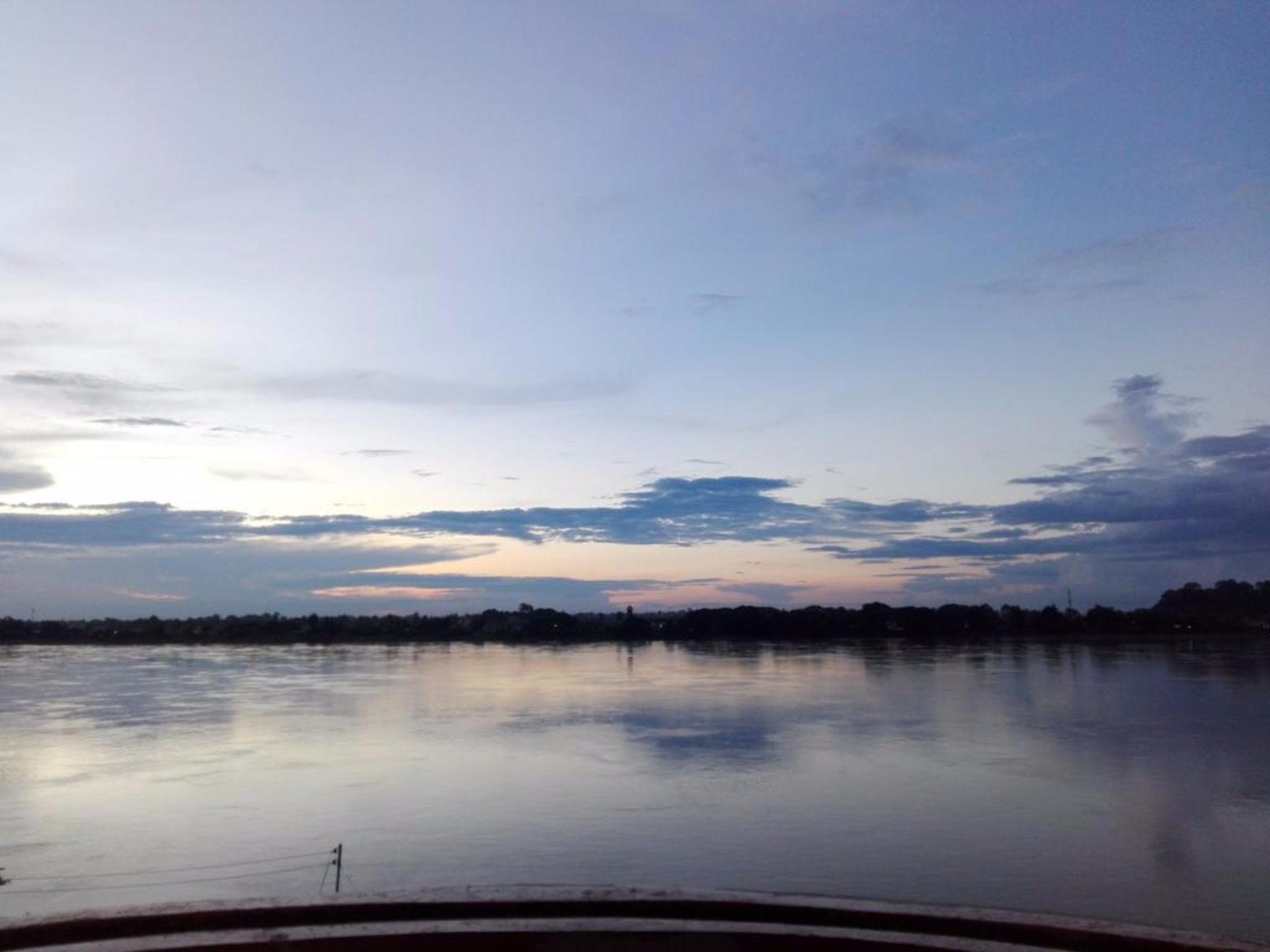 A calm lake with a clear sky and a distant shoreline.
