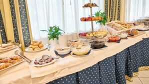 Una mesa de buffet con diversos alimentos y una presentación escalonada de frutas.