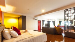 A hotel room with a large bed, a desk, a TV, and a kitchen area. - Gallery Lake View Hotel (Khon Kaen)