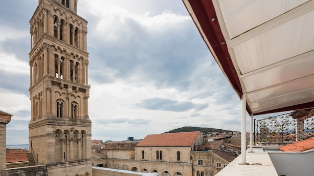 A historic building with a prominent tower, a courtyard with columns, and a view of the surrounding cityscape. - PLR Accommodation (Split)
