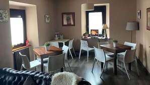Un soggiorno moderno con divano, tavolo da pranzo, sedie e televisione.