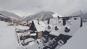 Un villaggio innevato con case tradizionali e montagne sullo sfondo.