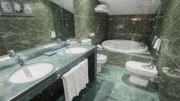 Un baño moderno con dos lavamanos, inodoro y bañera.