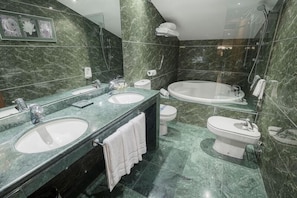 Un baño moderno con dos lavamanos, inodoro y bañera.