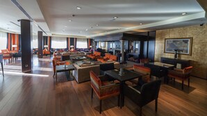 A spacious hotel lobby with multiple seating areas, including sofas and chairs, and a bar area. - Hospedium Hotel Mirador De Gredos (Barco De Avila)