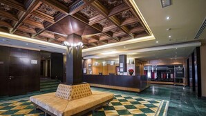 A lobby with a checkered floor, a tufted sofa, a reception desk, and a decorative ceiling. - Hospedium Hotel Mirador De Gredos (Barco De Avila)