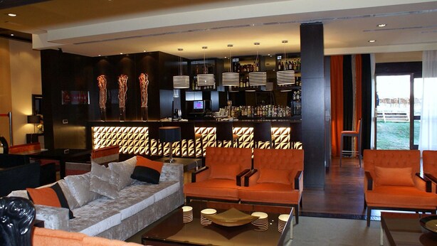 A modern lounge area with sofas, a bar, and ambient lighting. - Hospedium Hotel Mirador De Gredos (Barco De Avila)