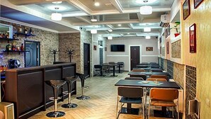 A restaurant with a bar area, multiple tables, and chairs. - Vila Lolo (Chisinau)