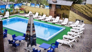 Een seizoensgebonden buitenzwembad, parasols voor strand/zwembad