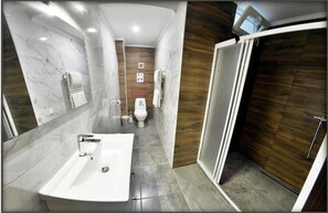 A modern bathroom with a marble sink, a toilet, and a shower area. - Vila Lolo (Chisinau)