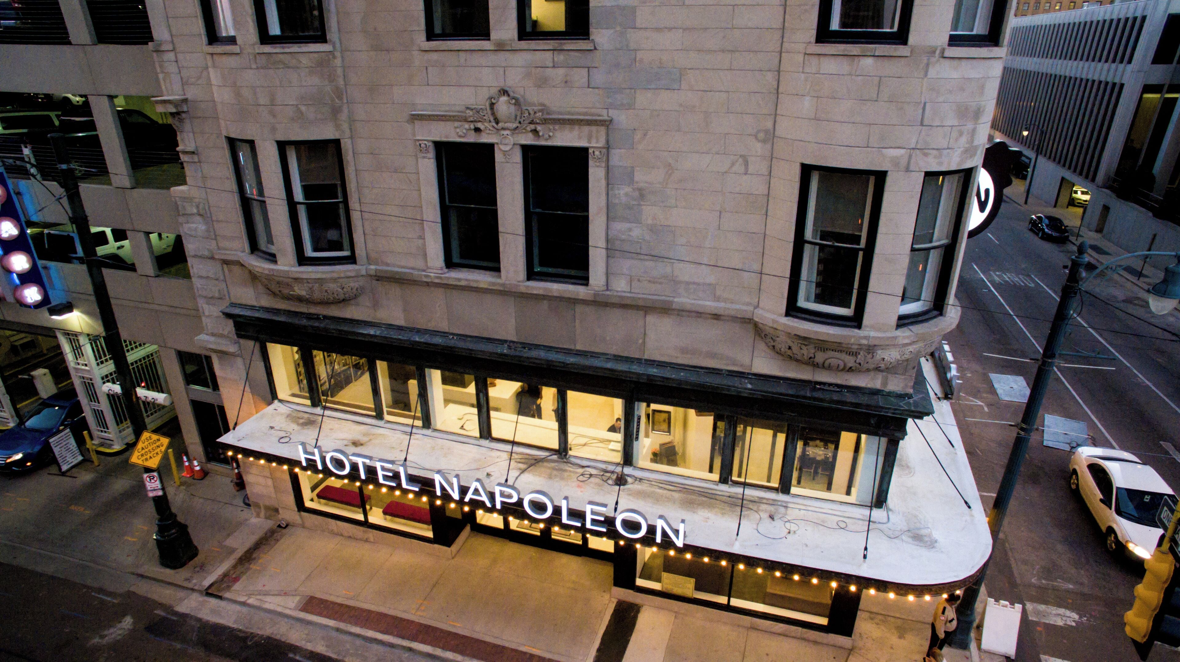 Een hotel genaamd “NAPOLEON” met een opvallende ingang, grote ramen en uitzicht op de straat.
