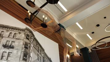 A modern interior with a unique hanging light fixture and a mural of an old building.
