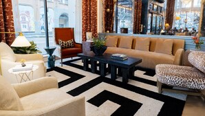 Una sala de estar moderna con un sofá, sillones y una mesa de centro.