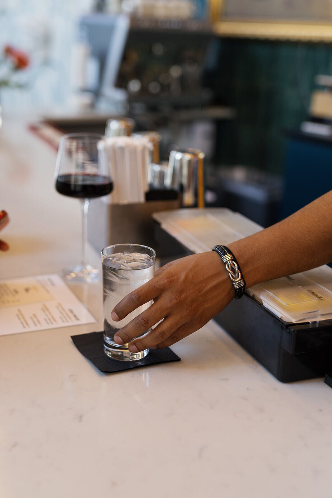 Une personne verse de l’eau dans un verre sur le comptoir d’un bar.