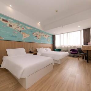 Ein Hotelzimmer mit zwei Betten, einem Schreibtisch, einem Stuhl und einer Weltkarte an der Wand.