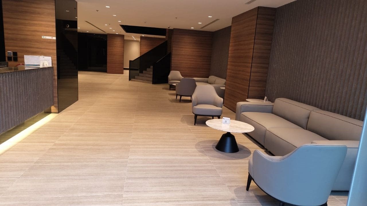 Un vestíbulo moderno con mostrador de recepción, zona de estar y escalera.