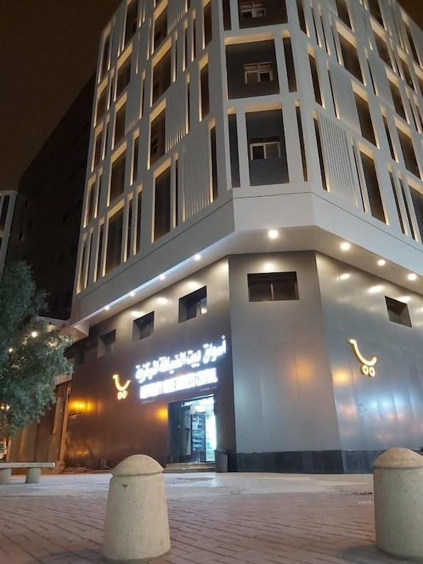 A modern building with a prominent entrance and illuminated signage. - Manazil Aldiyaafa Company for Serviced Apartments (Riyadh)