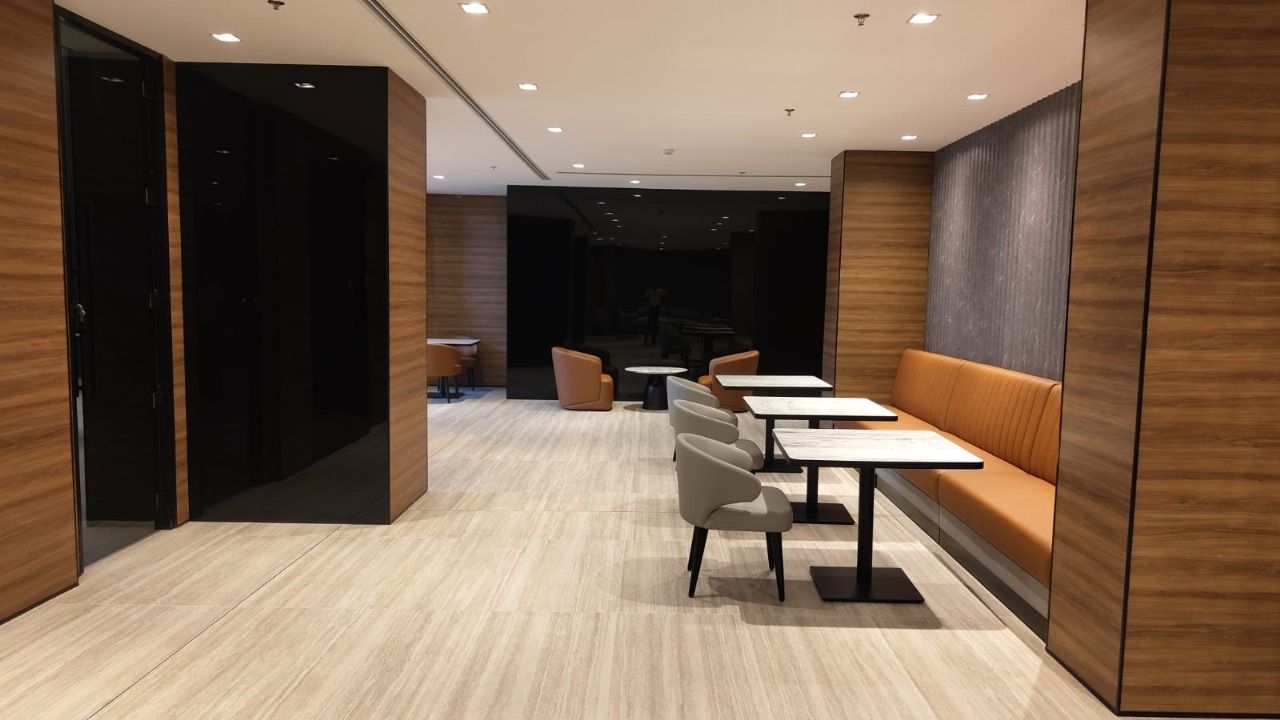 A modern interior with a seating area, tables, and a piano.