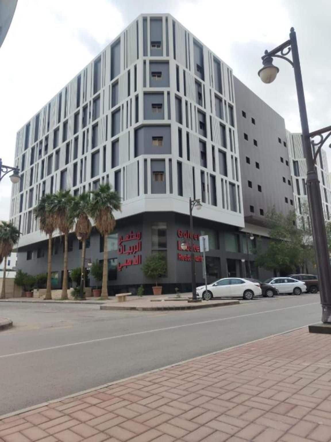 Un edificio moderno con fachada curva, varias ventanas y un letrero que indica un restaurante.