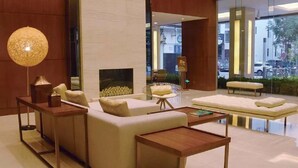 A modern lobby with a sofa set, a wooden coffee table, and a floor lamp. - Deacon House Wuxi (Wuxi)