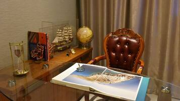 A glass table with a map, a globe, and a ship model.
