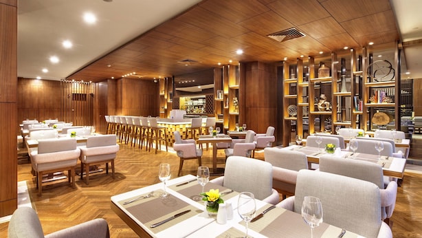 A spacious restaurant with wooden paneling, multiple dining tables, and chairs. - Deacon House Wuxi (Wuxi)
