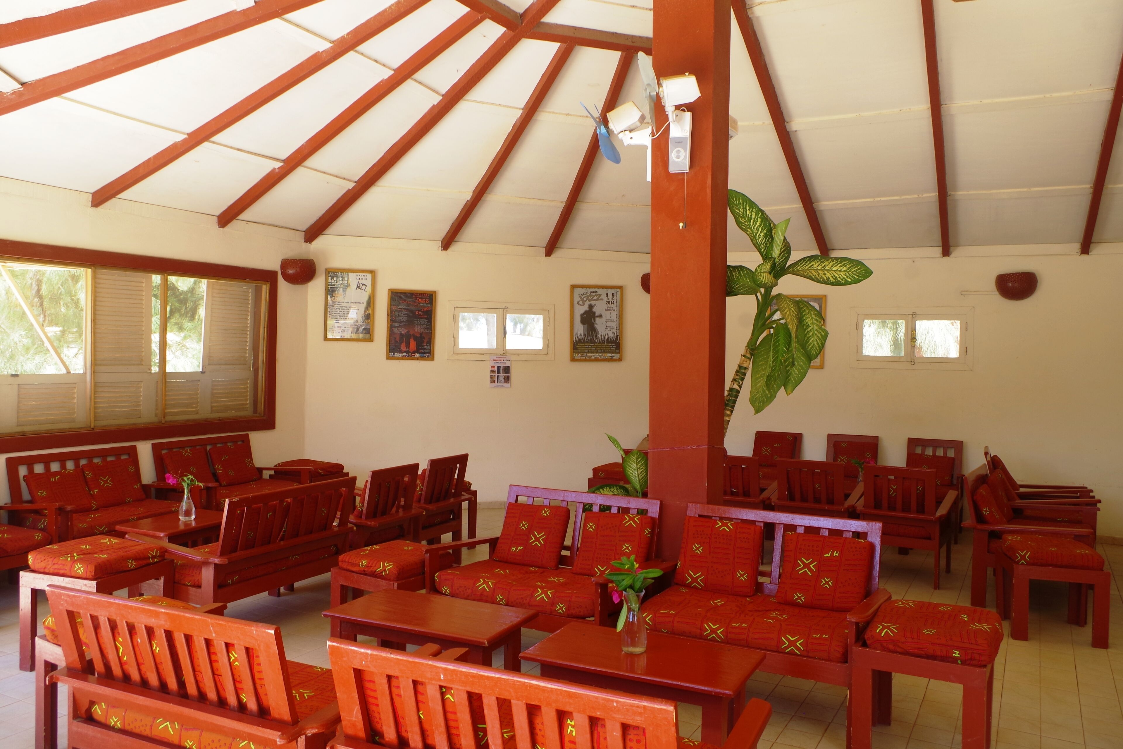 A spacious indoor seating area with wooden furniture and a high ceiling with wooden beams.