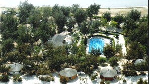 Un endroit isolé, bordé d’arbres, où se trouvent plusieurs huttes rondes en forme de dôme, une piscine et d’où l’on peut admirer une vue dégagée sur le paysage environnant.