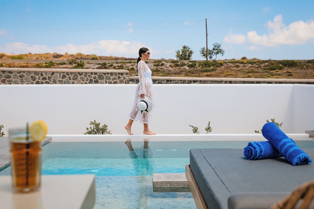 A person walking along a poolside with a clear view of the surrounding landscape.