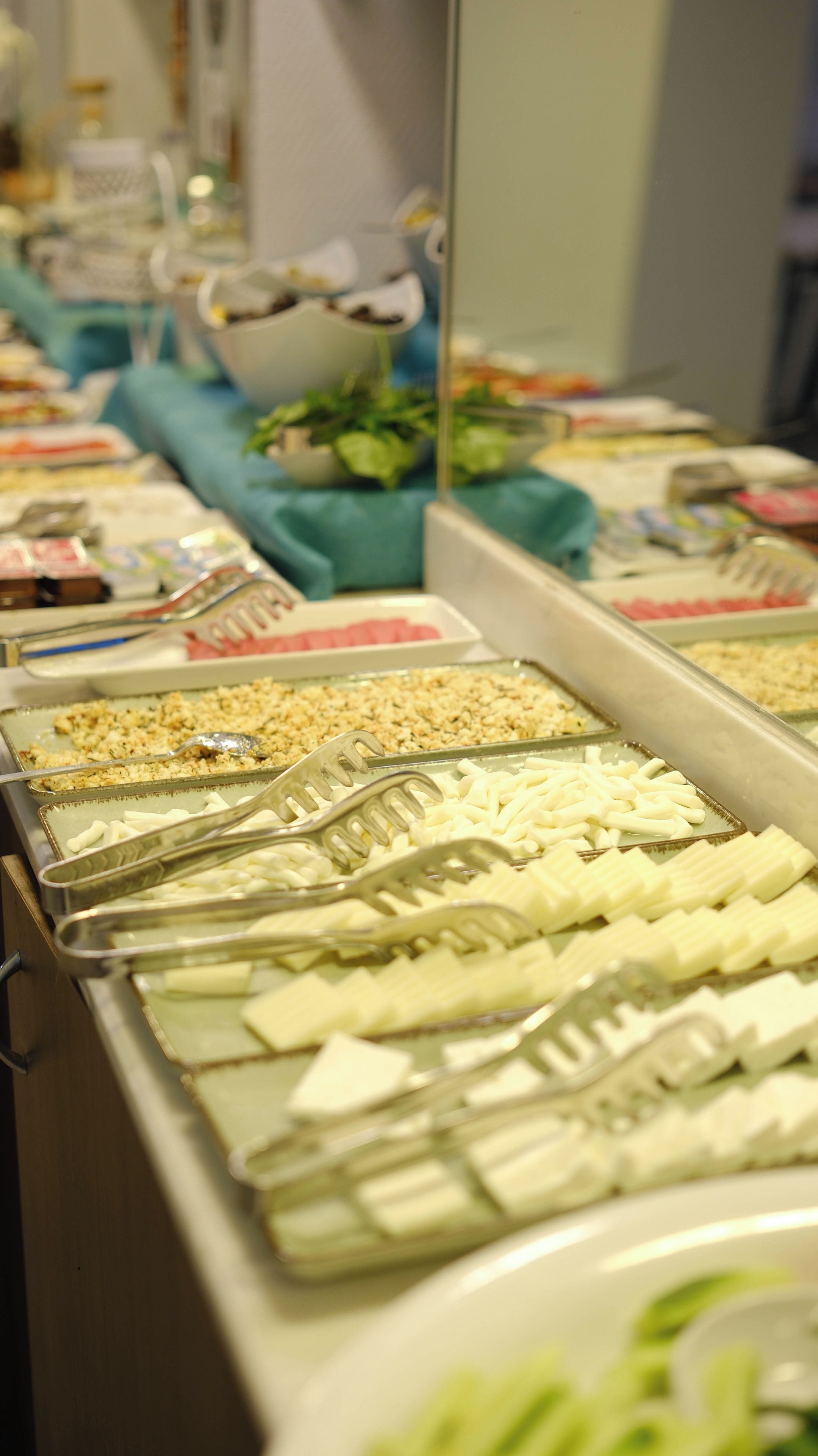 A buffet with various food items and utensils.